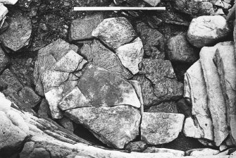 Excavation photograph : trench Z - detail of cover slabs to earth house L999 shaft prior to removal.

