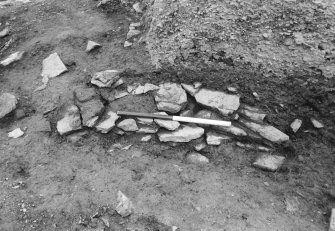 Excavation photograph :  trench R - L1891 packing beneath round house wall.

