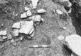 Excavation photograph :  trench R - stone packing L1710 below round house wall L1707.

