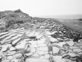 Excavation photograph : Extended entrance passage, wide steps dismantled, wide slabs to west.