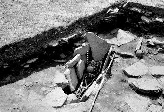 Excavation photograph : grave II : the seated burial in a long cist.