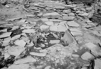Excavation photograph : pebble pit amid flagstones in settlement area.
