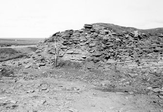 Excavation photograph : broch wall, sectioned by JCB showing sandy clay of core under stairs.