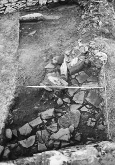 Trench 1, Area A, Upper Paved feature and coursed masonry abutting broch wall, after cleaning.  From South.