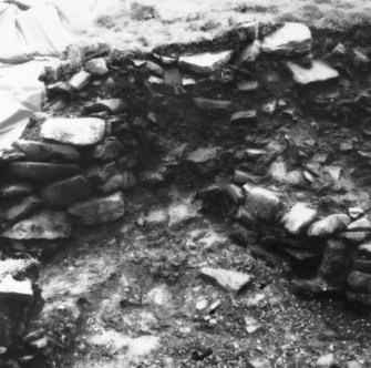 Excavation photograph -  Trench 2:f3 wall turning sea wards (uphill) and W end of trench 1/area A/extension, f4, from NW.
Photographic copy of polaroid print. Copied 1995.