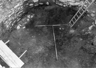 Excavation photograph : rubble and charcoal rich soils (f104) before removal, from NW.