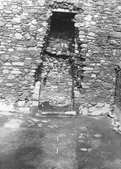 Excavation photograph : fireplace in north wall of E range showing moulded sandstone front of hearth in situ.