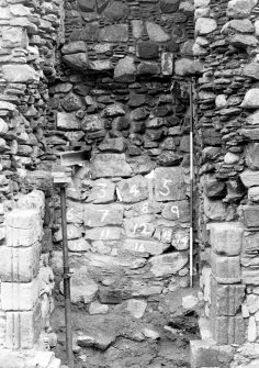 Excavation photograph : back of fireplace in N wall of E range, from S.