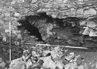 Excavation photograph : S wall after further collapse showing part of arch supporting stair to first floor of E range and gatehouse, from N.