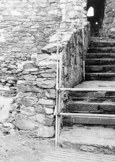 Excavation photograph : S wall of range and steps leading to first storeys of E range and gatehouse, from W.