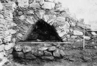 Excavation photograph : arched recess in E end of S wall, partially exposed, rubble f231 still in situ at front, from N.