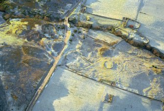 Oblique aerial view of enclosure and hut circles at Achvrail Burn, Rossal, Strath Fleet, East Sutherland, looking W.  