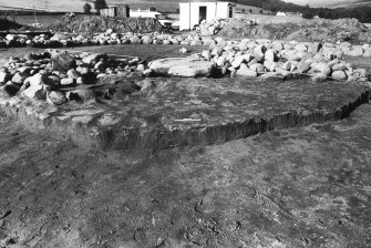 Excavation photograph : relationship of cist slab and pyre to cultivated surface.