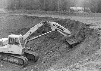 Excavation photograph.  Hymac on quarry face.