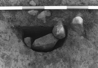 Excavation photograph : area 5 - F037 - half section of stone packed post hole from NE.