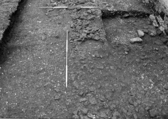 Excavation photograph : trench 2, stone spread f136 cut by trial trench.