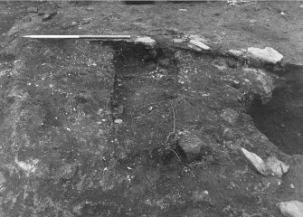 Excavation photograph : orange burnt material and stoney deposit f260, below f148, from N.