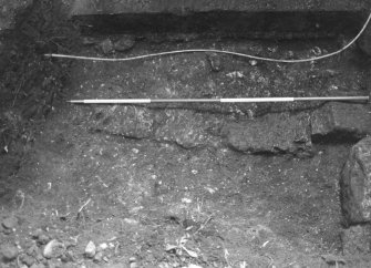 Excavation photograph : trial trench 2 - close up of masonry wall below modern precinct wall in SE corner of garden, from W.