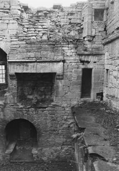 Excavation archive: SW corner of interior of tower, showing second floor fireplace and doorway into garderobe chamber in S wall. From N.