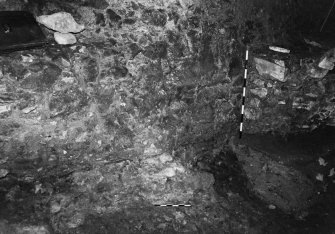 Excavation photograph : area A - light coloured mortar spreading over fragment of footing 14 and bedrock, sealed by walls 12 and 13.