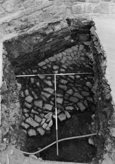 Excavation photograph : area J - cobbles cut by pipe trench.