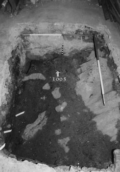Excavation photograph : area P - trial hole in SW corner of drill hall - cleaned to reveal surface 1005, worn bedrock and wall base 1006.