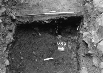 Excavation photograph : area N - slot cut through 988 with posthole 990 in base.