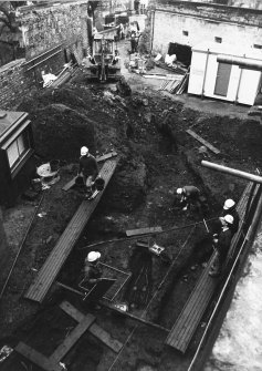 Excavation photograph : area M - people at work on skeletons.