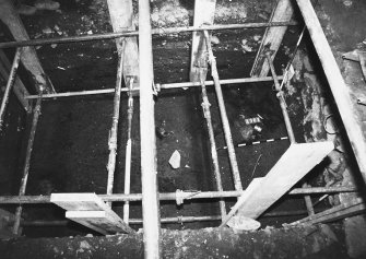 Excavation photograph: area X - hearth in NW corner of trench and rectangular stone, from east.