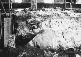 Excavation photograph: area H/X - showing surviving midden material on top of bedrock, sealed by demolition rubble from Storekeepers House.