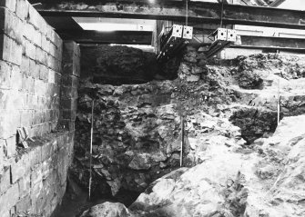 Excavation photograph: area H/X - wall of Storekeepers house showing slope of bedrock.