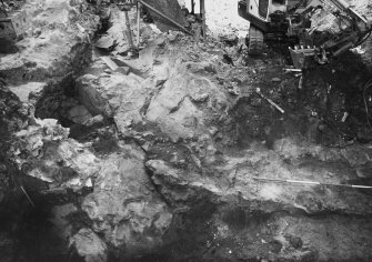 Excavation photograph: area H/X - working shots of wall 1066, N-S wall, and N wall of cart shed, slope of bedrock.