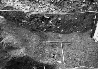 Excavation photograph: area X/H - low angle of W side of trench showing ditch to N of Charles II wall.