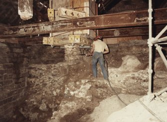 Excavation photograph : contractor's working removing dwarf wall beneath cart shed fireplace.