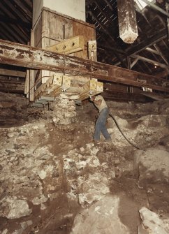 Excavation photograph : contractor's working removing dwarf wall beneath cart shed fireplace.