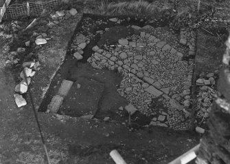 Excavation photograph : trench A - modern disturbance and flagged floor of Barmkin from south.