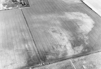 Oblique aerial view centred on the cropmarks of the enclosures, ring-ditches, pits, possible long barrow and timber halls, taken from the W.