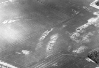 Oblique aerial view centred on the cropmarks of the ring-ditches, roundhouses and long barrow, taken from the S.