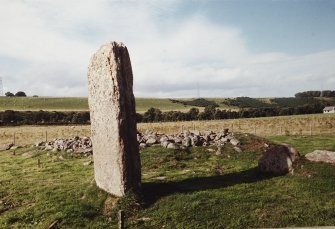 Excavation photograph : standing stone and cairn from south-west.