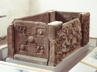 Three-quarter view of sarcophagus, from the left.
(Panels 1, 1A,  corner posts 1B, 1C, 1D)