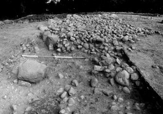 Excavation photograph : outer kerb apparently laid on spread from stone cairn.