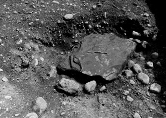 Excavation photograph : cist pit cut into natural gravel (013) and capstone (015) from west.