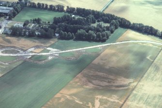 Aerial view of Brackla ring ditch cropmarks, airfield and distillery, near Cawdor, E of Inverness, looking SE.