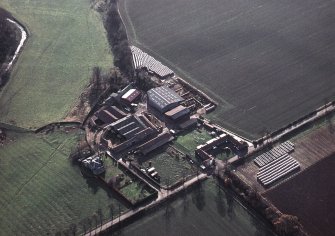 Oblique aerial view centred on the farmhouse and farmsteading, taken from the NNE