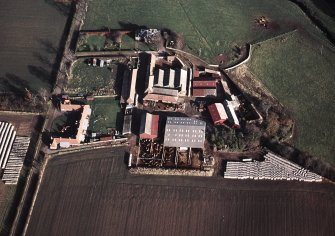 Oblique aerial view centred on the farmhouse and farmsteading, taken from the WSW