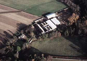 Oblique aerial view centred on the farmhouse and farmsteading, taken from the WSW