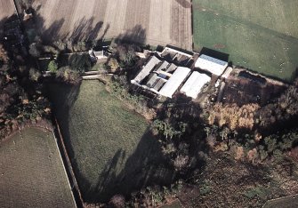 Oblique aerial view centred on the farmhouse and farmsteading, taken from the S
