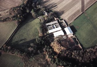 Oblique aerial view centred on the farmhouse and farmsteading, taken from the SE