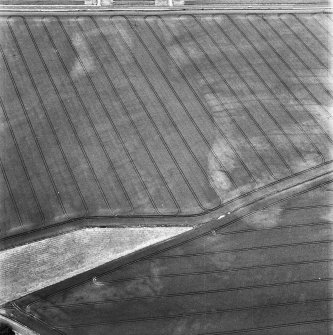 Balcathie, oblique aerial view, taken from the NNW, centred on the cropmarks of two pit-alignments, and showing further cropmarks including those of an enclosure in the centre right of the photograph.