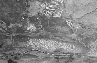 Oblique aerial view centred on the remains of the field-system and sheepfolds, taken from the ESE.